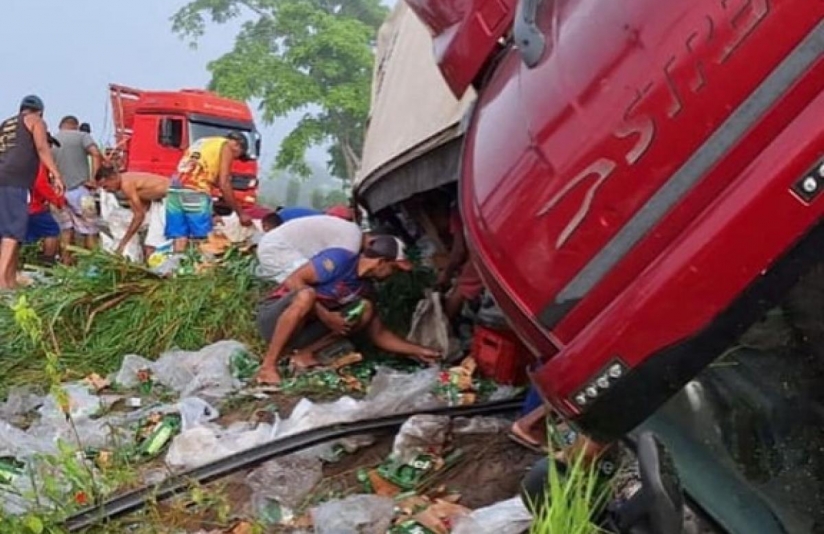 Caminhão carregado de cerveja tomba e é saqueado pela população